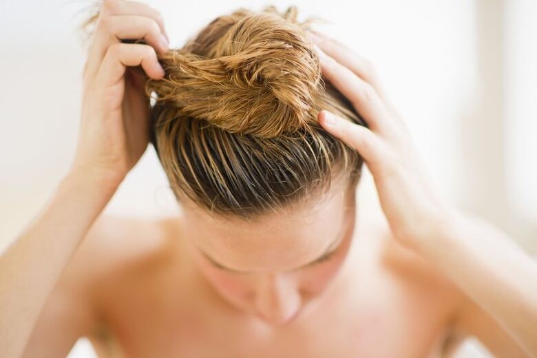 Das Mädchen trug ein Produkt gegen Haarausfall auf ihr Haar auf.